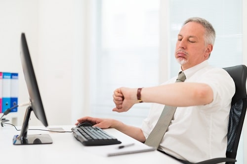 Homme qui soupire en regardant sa montre